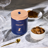 Blue container labeled 'DISCOFF' on a marble surface with a bowl of brown substance and a spoon.